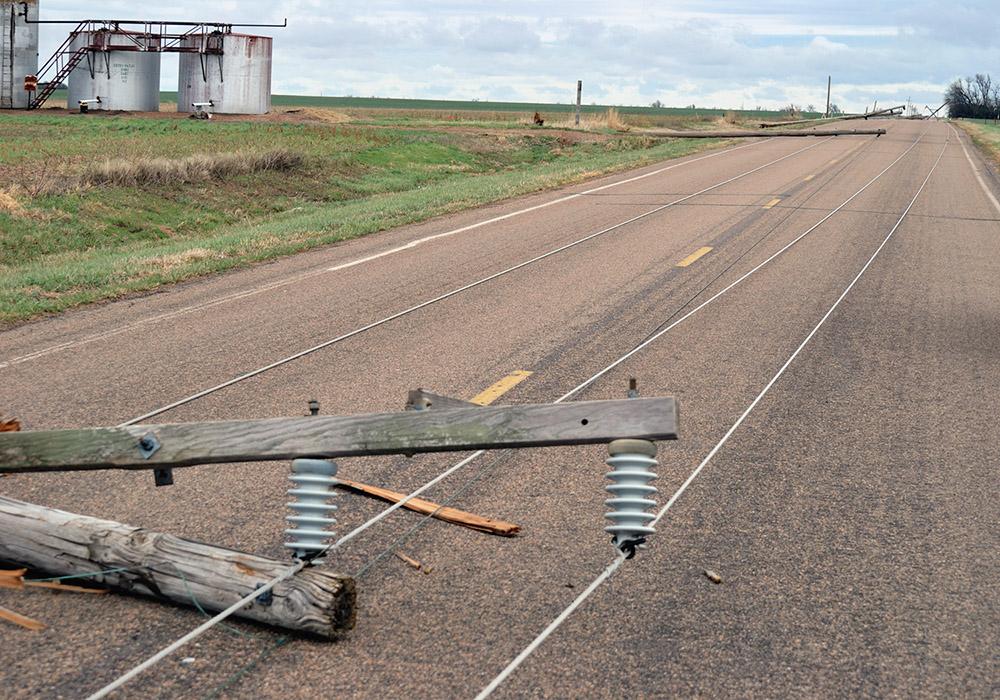 堪萨斯州切斯附近，暴风雨过后，电线和电线杆横躺在一条乡村公路上.